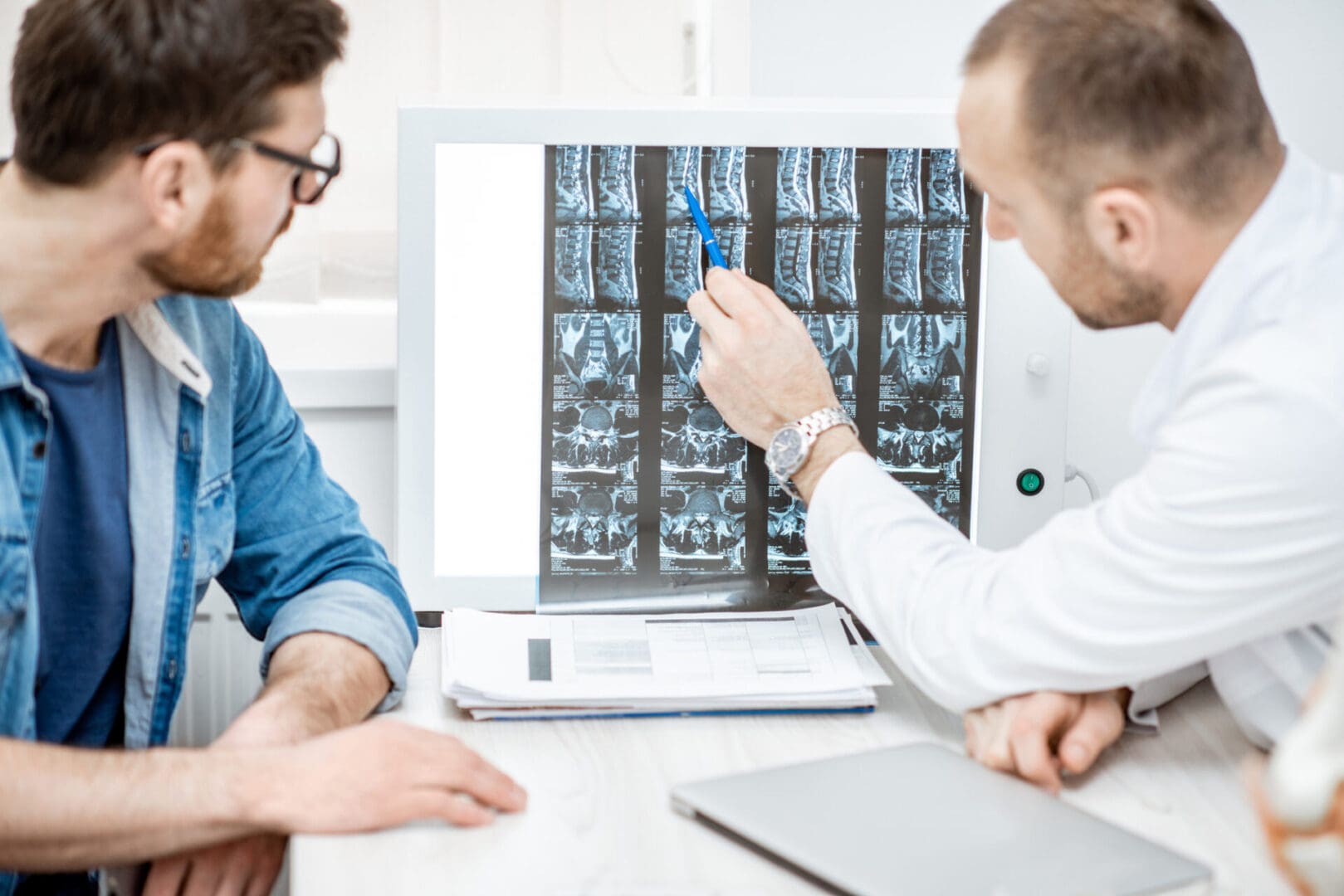 Doctor and patient reviewing spinal X-rays.